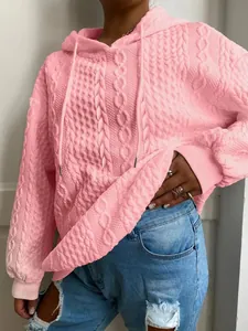 Primer plano de sudadera con capucha rosa para mujer con textura de punto de cable