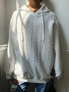 Detalle que muestra la textura de punto de ochos blanco en sudadera de invierno mujer