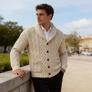 Detail einer cremefarbenen Herren-Strickjacke mit Schalkragen und Zopfmuster im Freien