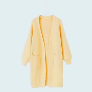 Detailansicht einer langen gelben Strickjacke mit zwei Taschen für Damen im Winter.