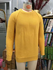 Detailed close-up of a bright yellow raglan sleeve knit sweater on a professional mannequin