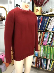 Close-up detail of a dark red crew neck knitted sweater featuring raglan sleeve design for men