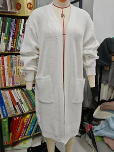 Detailansicht einer langen weißen Strickjacke für Damen an einer Schaufensterpuppe