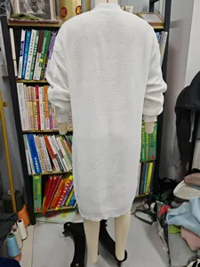 Detaillierte Rückansicht eines langen, cremefarbenen Grobstrick-Cardigans auf einem Mannequin