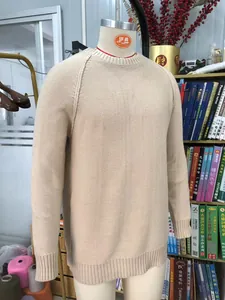 Detailed close-up of a beige raglan sleeve knit sweater displayed on a mannequin