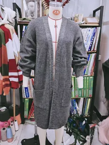 Detailansicht eines langen grauen Strick-Cardigans an einer Schaufensterpuppe in einem Studio