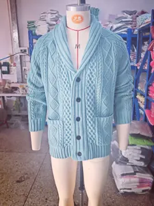Detaillierte Vorderansicht mit Zopfmuster und Schalkragen an einer blauen Herrenstrickjacke