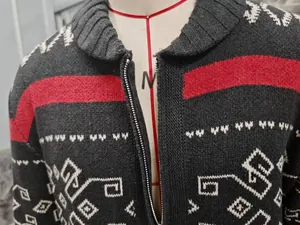 Detailed close-up of men's knitted cardigan with ethnic geometric patterns and zipper