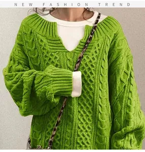 Primo piano di un maglione verde a trecce oversize con dettaglio dello scollo a V
