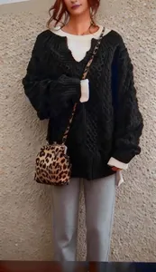 Dettaglio del maglione oversize a trecce nero con scollo a V da donna, look casual chic