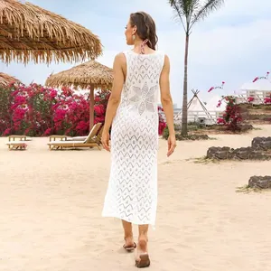 Full back view of a stylish white knitted hollow-out beach cover-up dress in a resort setting