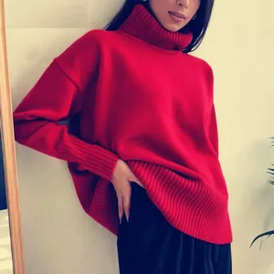 Close-up detail of a soft red oversized turtleneck knitted sweater with ribbed texture