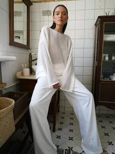 Détail d'un pull en maille ajourée blanche avec texture résille et coupe ample
