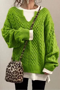 Dettaglio ravvicinato di maglione a trecce verde lime con trama spessa e scollo a V a costine