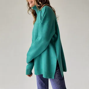 Close-up side view of a green loose-fit turtleneck knit sweater with unique side slit details