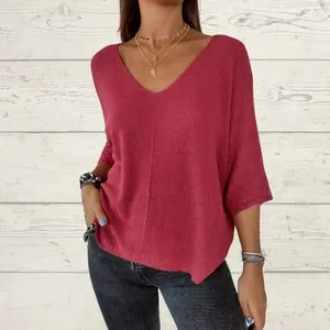 Detail of loose-fit V-neck reddish-pink knit top with stylish three-quarter sleeves