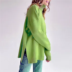 Side view of loose green turtleneck sweater with split hem and graphic detail