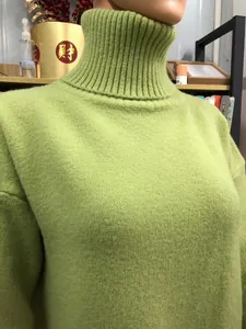Close-up of the ribbed high turtleneck on a soft light green knit sweater