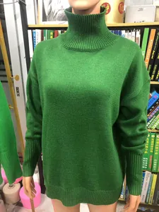 Detailansicht eines kräftig grünen Rollkragenpullovers mit grober Strickstruktur.