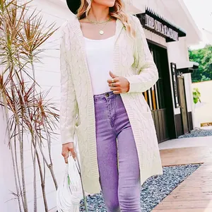 Detailed view of a stylish women's long cream hooded cable-knit cardigan sweater outdoors