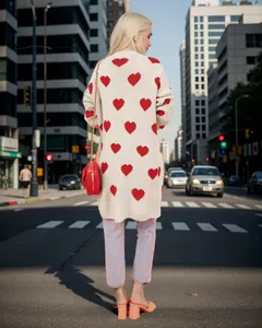 Back view of a woman wearing a cream long cardigan with stylish red heart patterns
