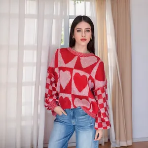 Dettaglio del motivo a cuore rosso e rosa sul maglione lavorato a maglia oversize