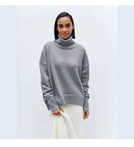 Detailed view of a soft grey turtleneck knit sweater with ribbed cuffs and hem