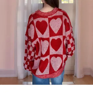 Vista posteriore di un maglione oversize a maglia rosso e rosa con motivo a cuori e vestibilità ampia