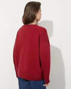 Vista posteriore di un maglione a maglia rossa oversize morbido e premium per donna in autunno.