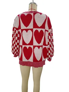 Vista posteriore di maglione lavorato a maglia oversize con cuori e scacchi rossi e bianchi