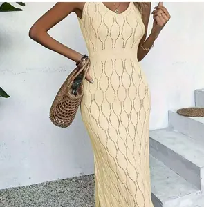 Detailed view of a beige knit beach dress with hollow-out pattern worn by a model.