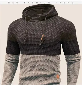 Close-up detail of a men's two-tone hooded knit sweater showing rich textured fabric pattern