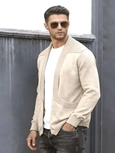 Detailaufnahme eines beigen Herren-Strickcardigans mit Schalkragen an einem Model.