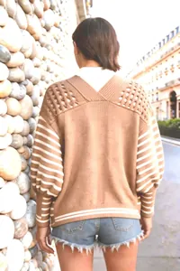 Dettaglio della vista posteriore di un cardigan in maglia marrone a righe bianche