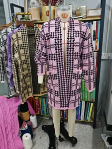 Detail view of a pink and black houndstooth long knit cardigan with large pockets.