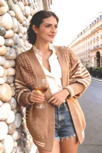 Donna alla moda che indossa un cardigan in maglia traforata kaki con maniche a righe