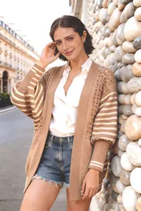 Dettaglio del cardigan in maglia traforata kaki con maniche a righe su modella