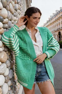 Dettaglio ravvicinato del cardigan verde in maglia traforata con maniche a righe