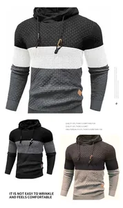 Detailed texture of men's color block knitted hoodie with waffle pattern and hood