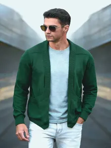 Detailansicht einer dunkelgrünen Strickjacke mit Schalkragen, die ein Model trägt