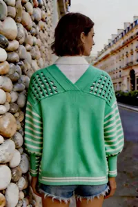 Vista posteriore di un cardigan in maglia a righe verdi con dettaglio traforato.