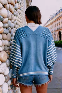 Vista posteriore dettagliata di un cardigan in maglia blu traforata con maniche a righe