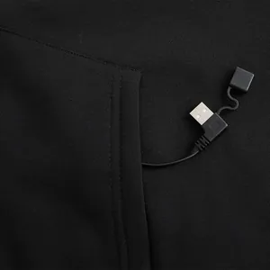 Macro detail of the USB charging connector and cable inside a black heated hoodie pocket