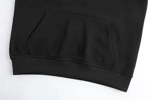 Detailed macro view showing the kangaroo pocket and ribbed hem of a black heated hoodie.