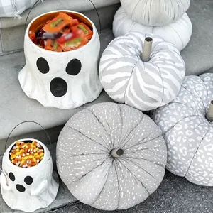 Gros plan sur des seaux à bonbons fantômes et des citrouilles en tissu pour Halloween