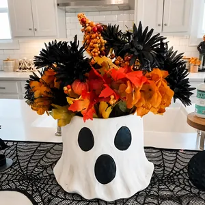 Détail du pot de fleur fantôme avec arrangement floral d'Halloween sur un chemin de table