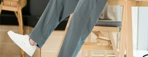 Détail d'un pantalon homme large en coton et lin montrant la texture grise du tissu