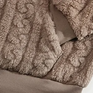 Detailed macro view of the warm plush sherpa fleece fabric and ribbed hem on a men's hoodie