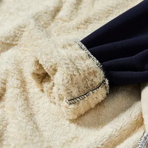 Détail de la doublure épaisse en polaire Sherpa beige et du revers bleu marine d'une veste