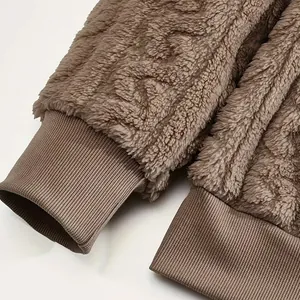 Macro view of ribbed elastic cuffs on a thick brown plush fleece hoodie.